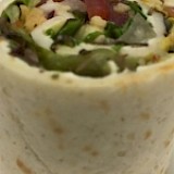 Vegetarisch wrap gevuld met roomkaas, tomaat, rucola en pijnboonpitjes