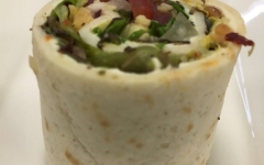 Vegetarisch wrap gevuld met roomkaas, tomaat, rucola en pijnboonpitjes
